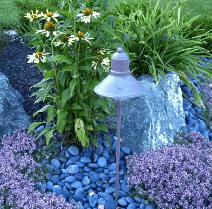 A garden with purple flowers and blue rocks.